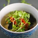 纯素味酱汤在碗里配寿司米饭，豌豆芽和磨碎的胡萝卜GydF4y2Ba