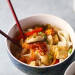 一碗日式乌冬面配豆腐和泡菜味增汤，用筷子。