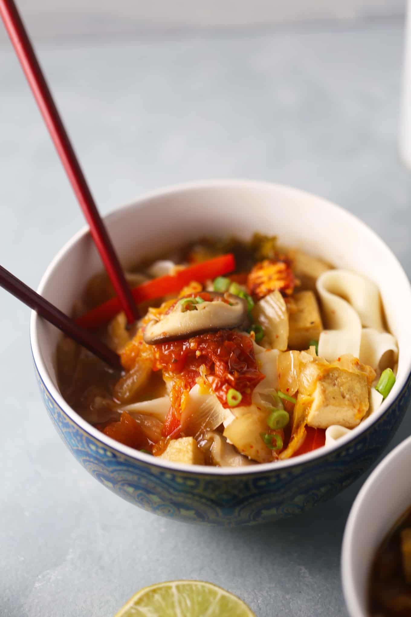 一碗日式乌冬面配豆腐和泡菜味增汤，用筷子。gydF4y2Ba